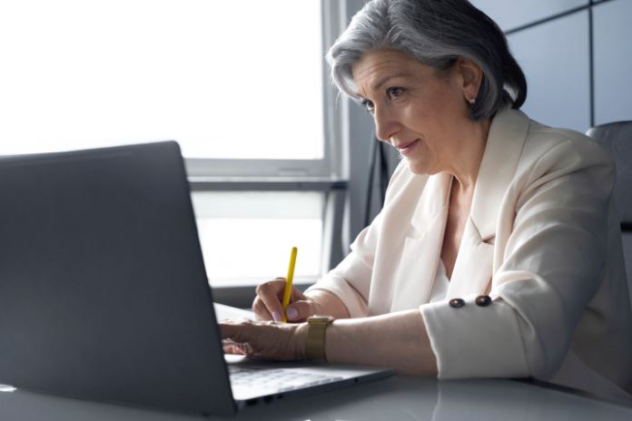 Uma empresária observa um gráfico de vendas em crescimento em uma tela digital, preocupado com as vendas da sua empresa.